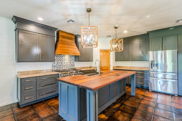 a kitchen with stainless steel appliances granite countertop a sink and a stove