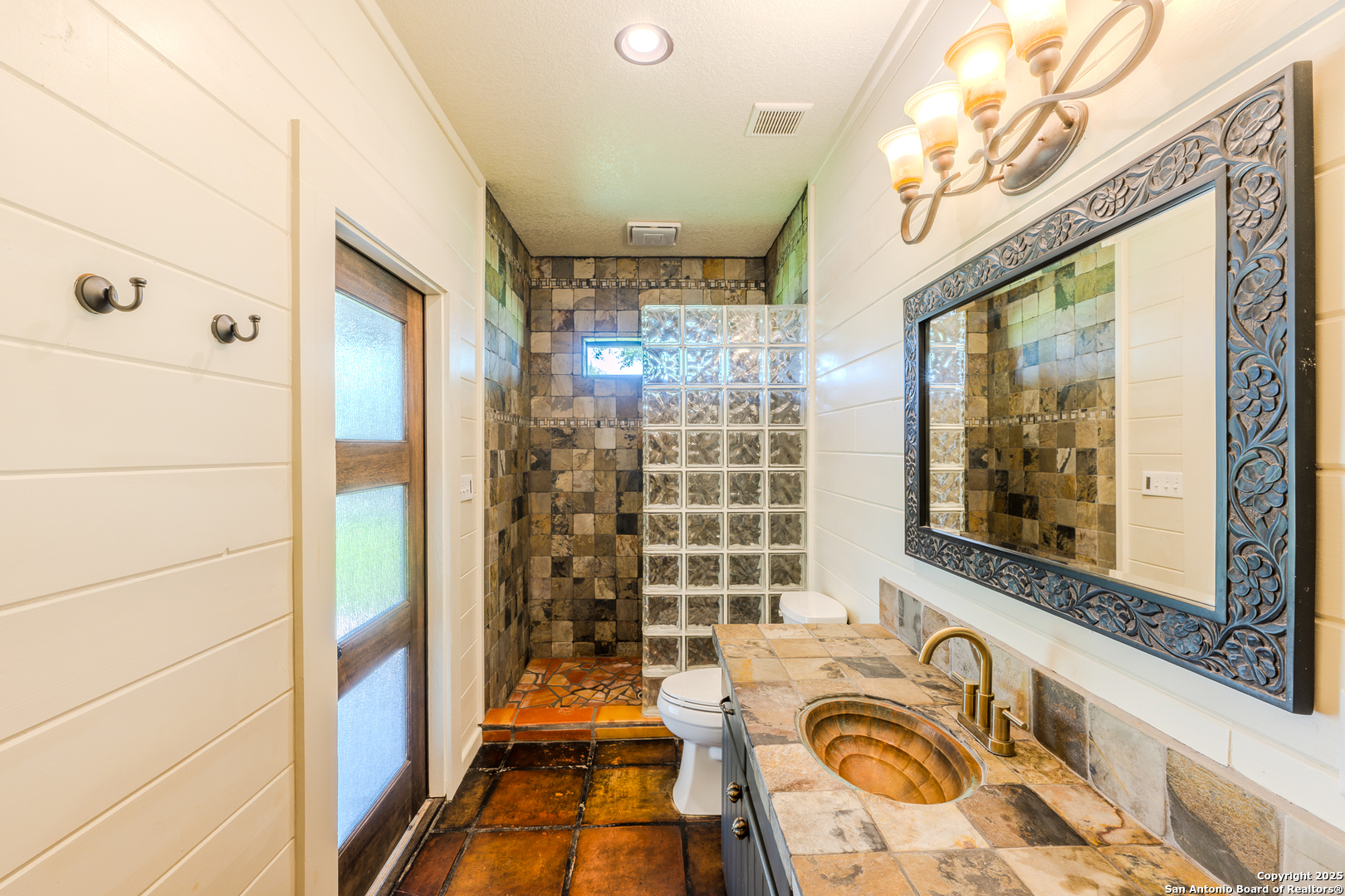 13831 Highway 127 Sabinal, TX 78881 - Photo 22 of 55 a bathroom with a granite countertop sink a mirror a bathtub and shower