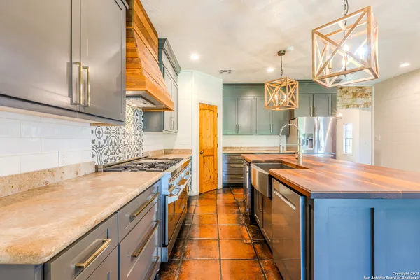 a kitchen with stainless steel appliances granite countertop a sink and a stove