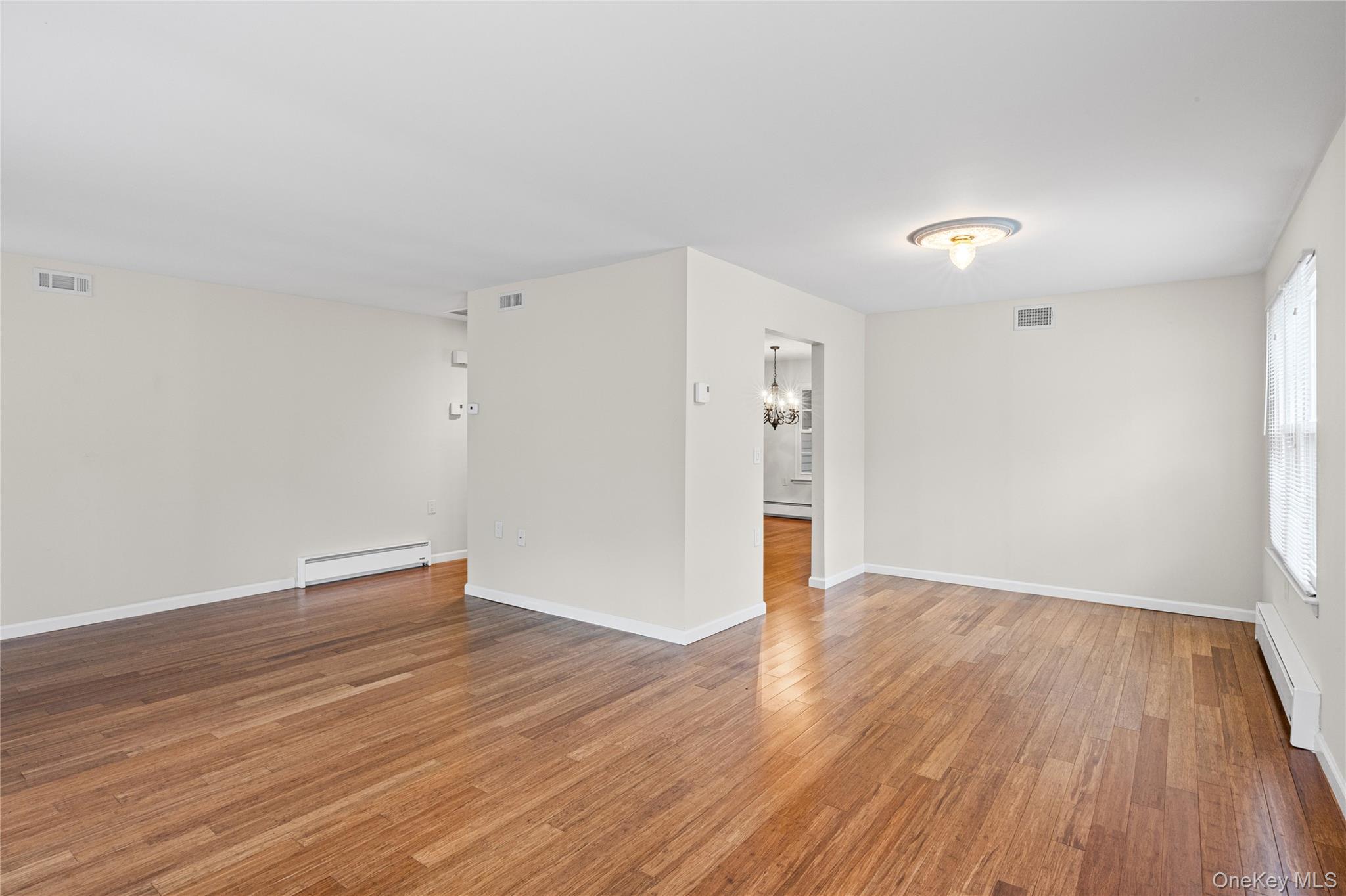 220 Belfast Lane Ridge, NY 11961 - Photo 10 of 44 a view of an empty room with wooden floor and a window