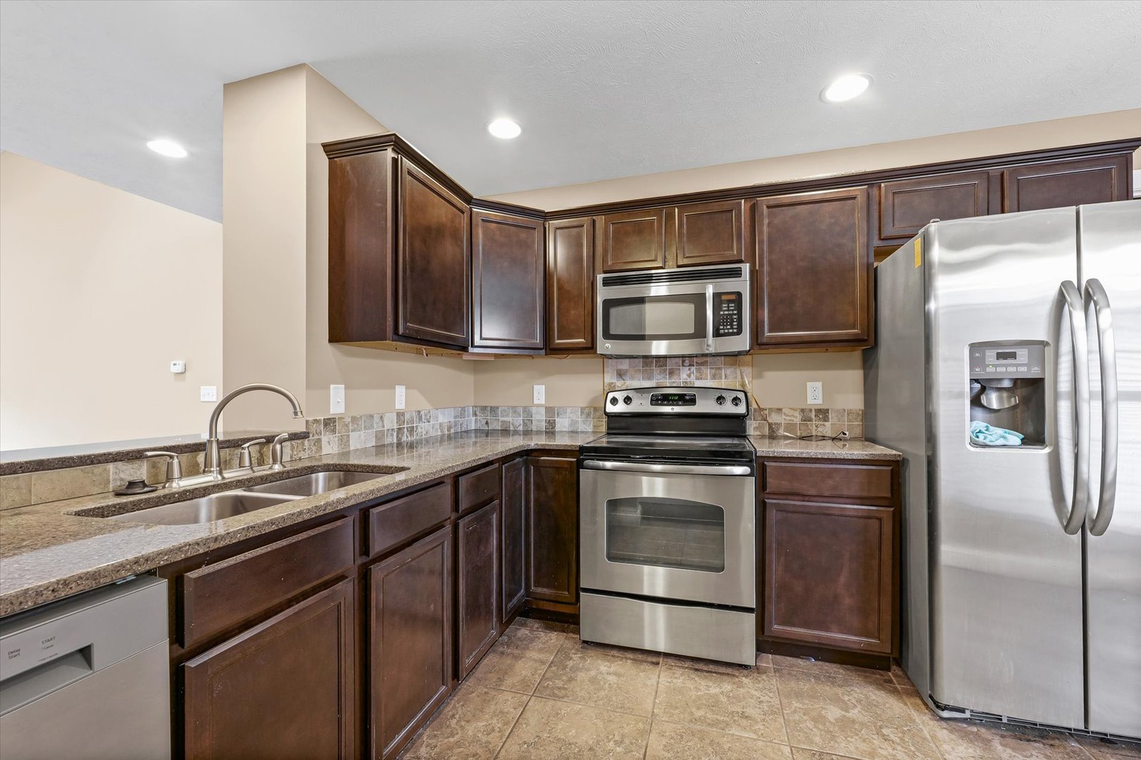2521 Pembrook Point Champaign, IL 61821 - Photo 11 of 31 a kitchen with stainless steel appliances granite countertop a sink stove and refrigerator