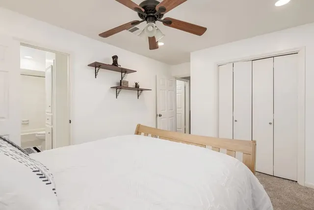 a bedroom with a large bed and a wall painting