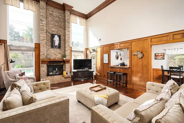a living room with furniture fireplace and a large window