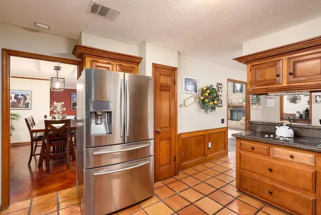 a kitchen with stainless steel appliances granite countertop a refrigerator and a sink