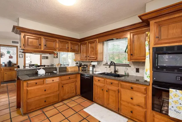 a kitchen with stainless steel appliances granite countertop a sink and cabinets