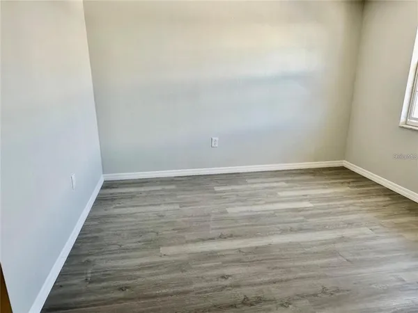 a view of an empty room with wooden floor