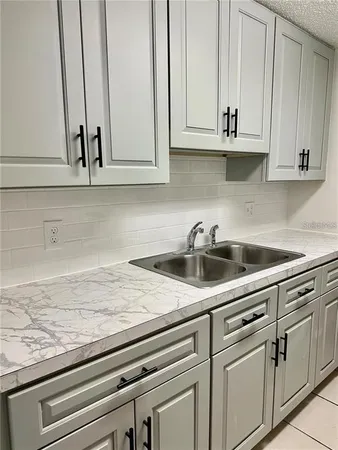a kitchen with white cabinets and a sink