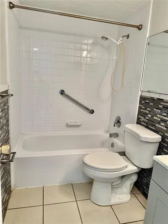 a white toilet sitting next to a bath tub and a shower