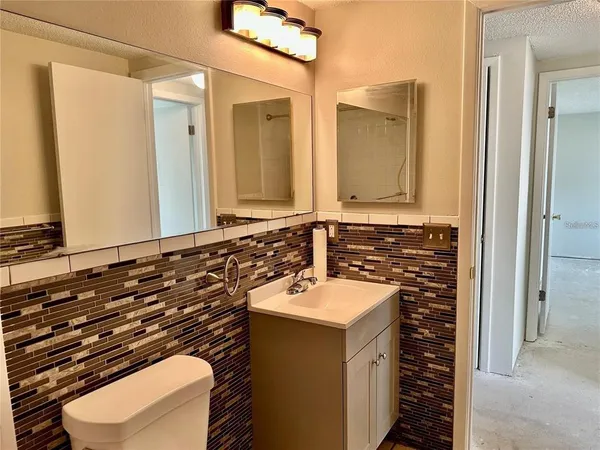 a bathroom with a sink a toilet and mirror