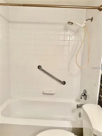a bathroom with a bath tub with a shower