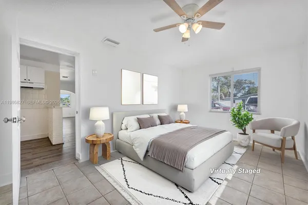 a spacious bedroom with a bed and a chandelier