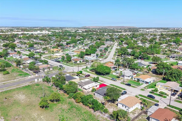 an aerial view of residential houses with outdoor space and trees