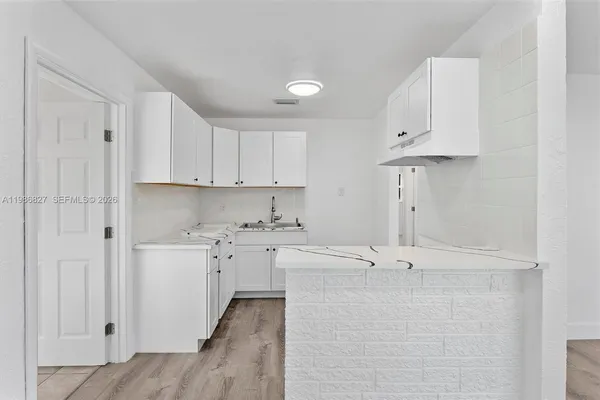 a view of a kitchen with stainless steel appliances cabinets a sink and a counter top space