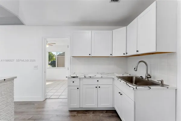 a kitchen with stainless steel appliances white cabinets and a sink