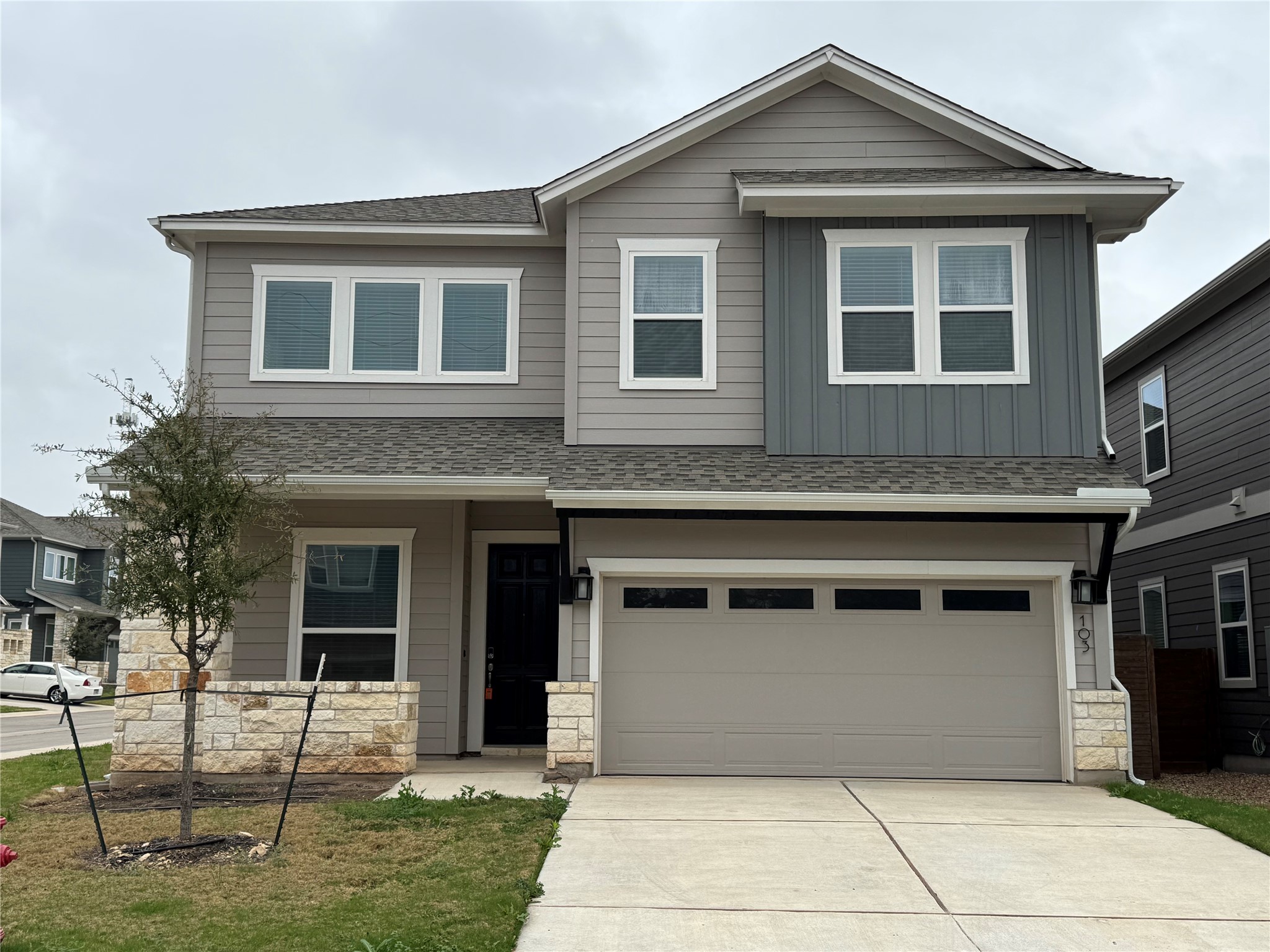 Craftsman house with stone siding, concrete driveway, roof with shingles, and an attached garage