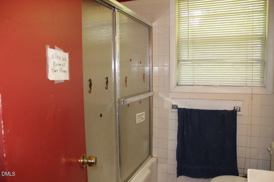 5109 Kaplan Drive Raleigh, NC 27606 - Photo 10 of 13 a bathroom with a shower and a mirror