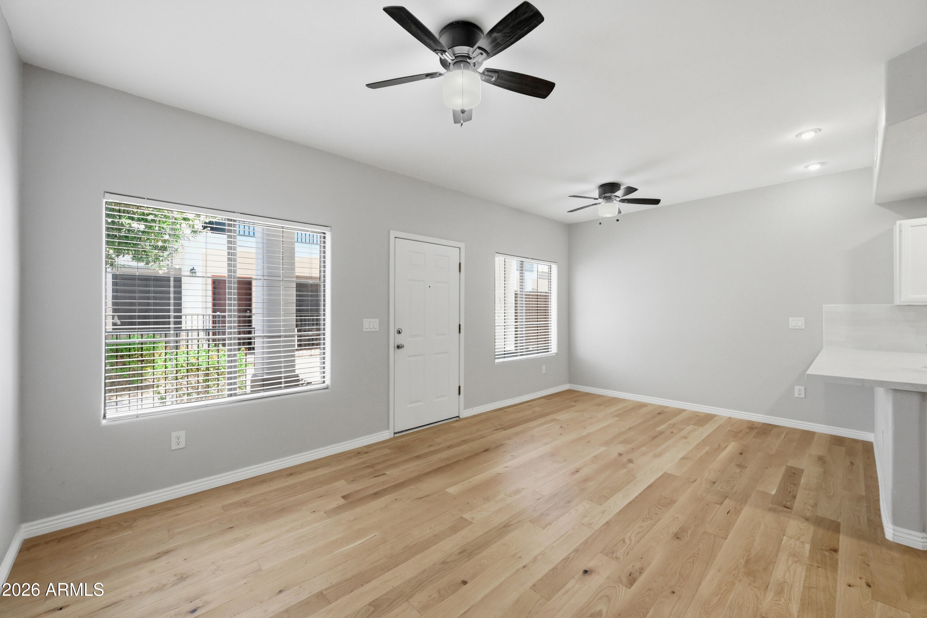 3150 East Beardsley Road, Unit 1009 Phoenix, AZ 85050 - Photo 8 of 31 a view of an empty room with a window and wooden floor