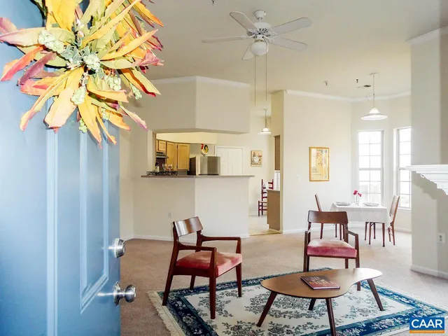 a dining room with furniture and a chandelier fan