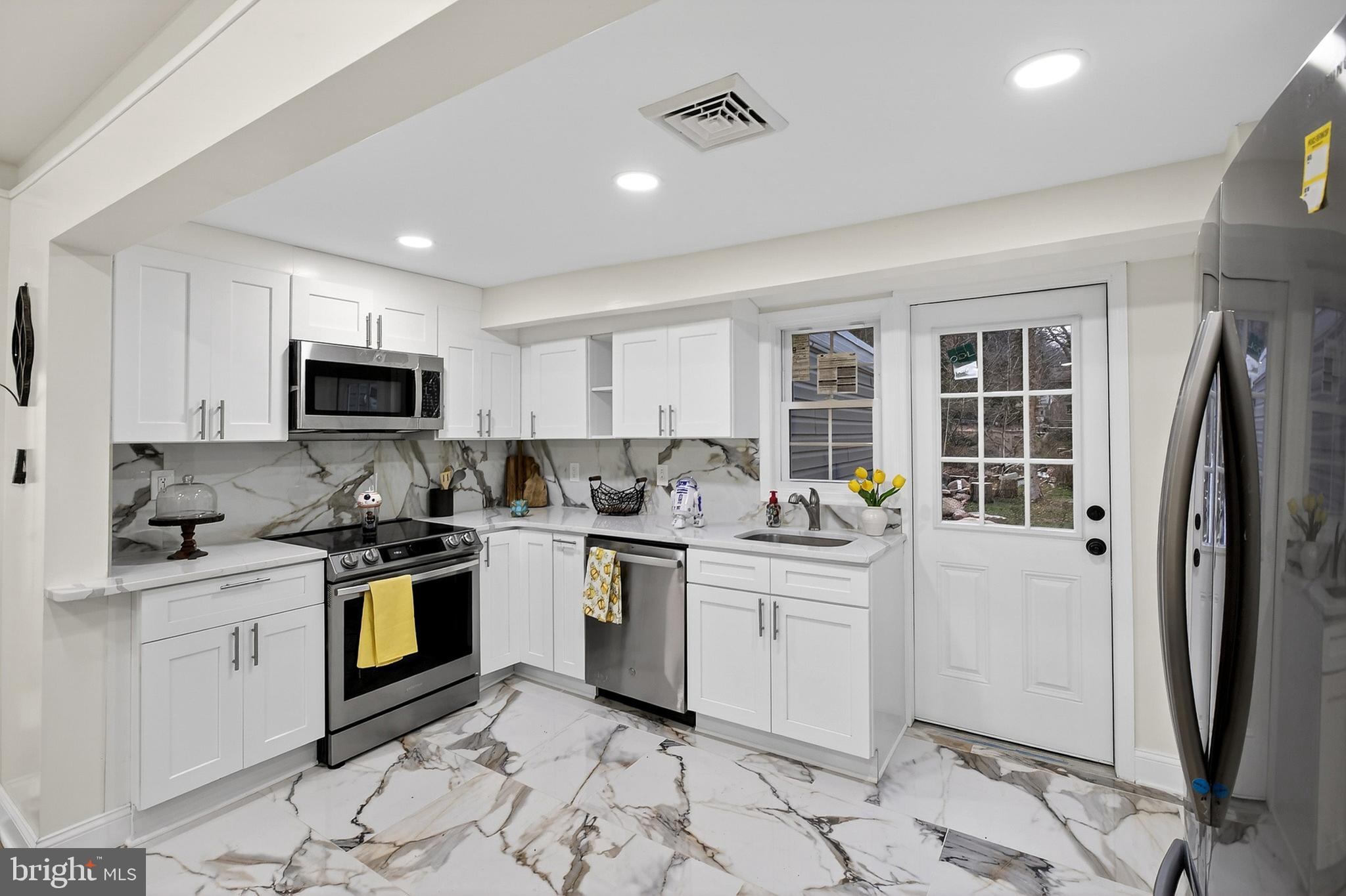 4 Lower Greenbriar Road Wilmington, DE 19810 - Photo 8 of 31 a kitchen with a sink stove and refrigerator