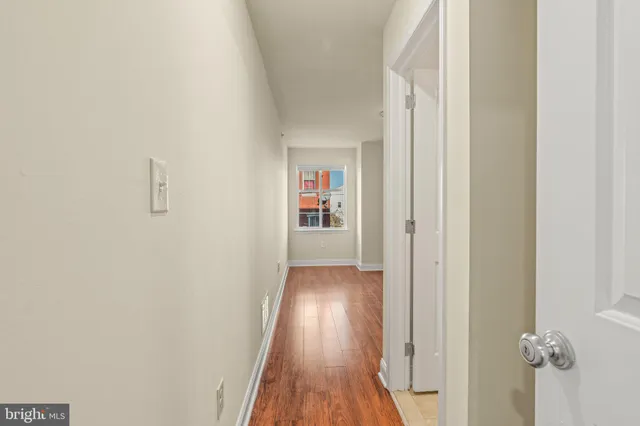 a view of a hallway with wooden floor