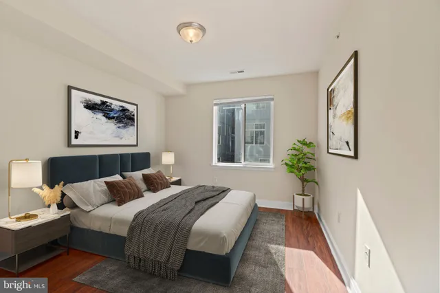 a bedroom with bed and a painting on the wall