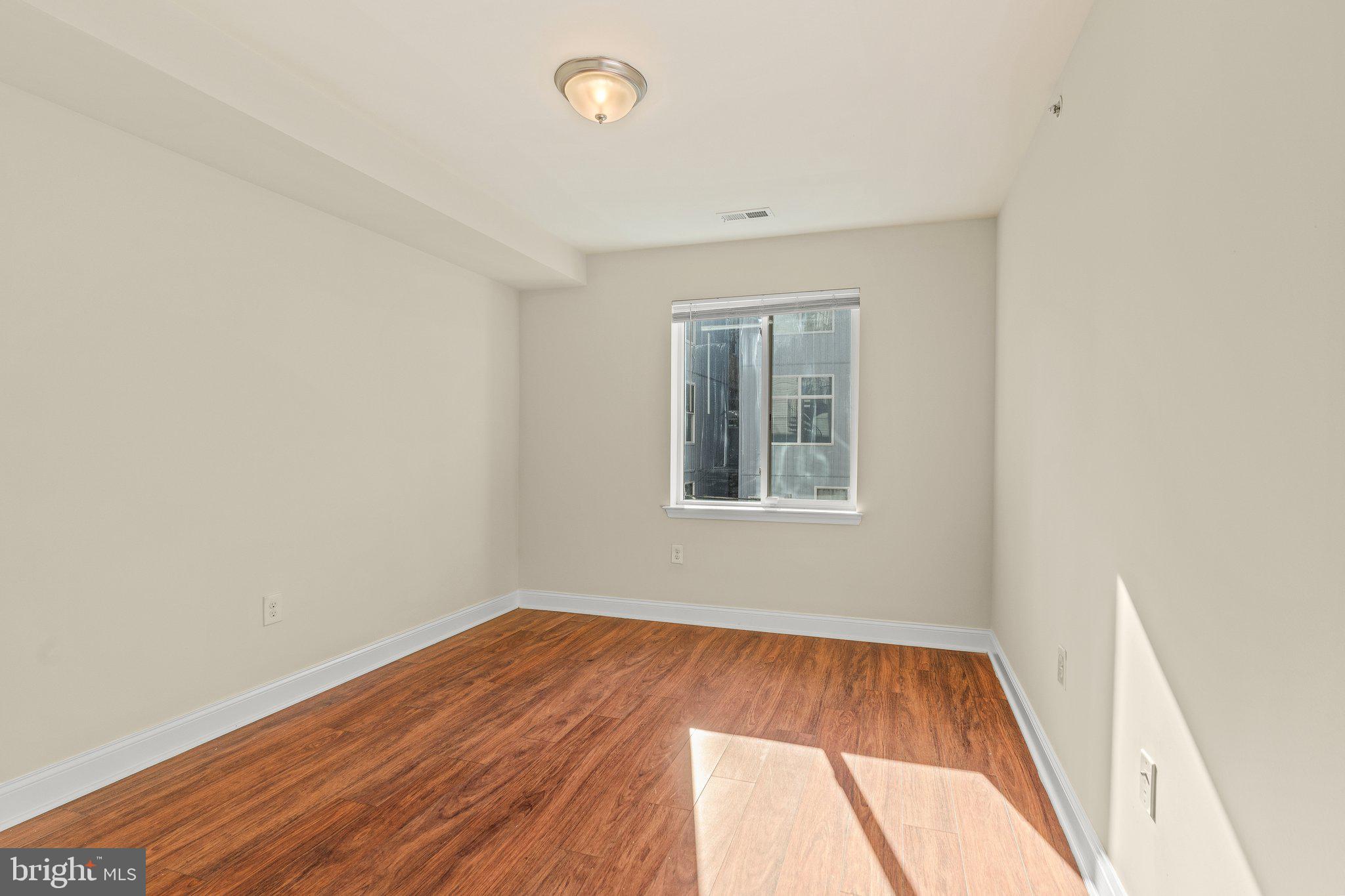1724 Master Street, Unit C Philadelphia, PA 19121 - Photo 22 of 26 an empty room with wooden floor and windows