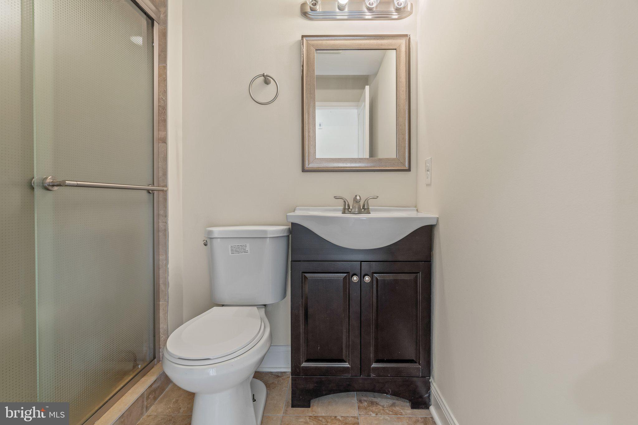 1724 Master Street, Unit C Philadelphia, PA 19121 - Photo 24 of 26 a bathroom with a toilet a sink and mirror