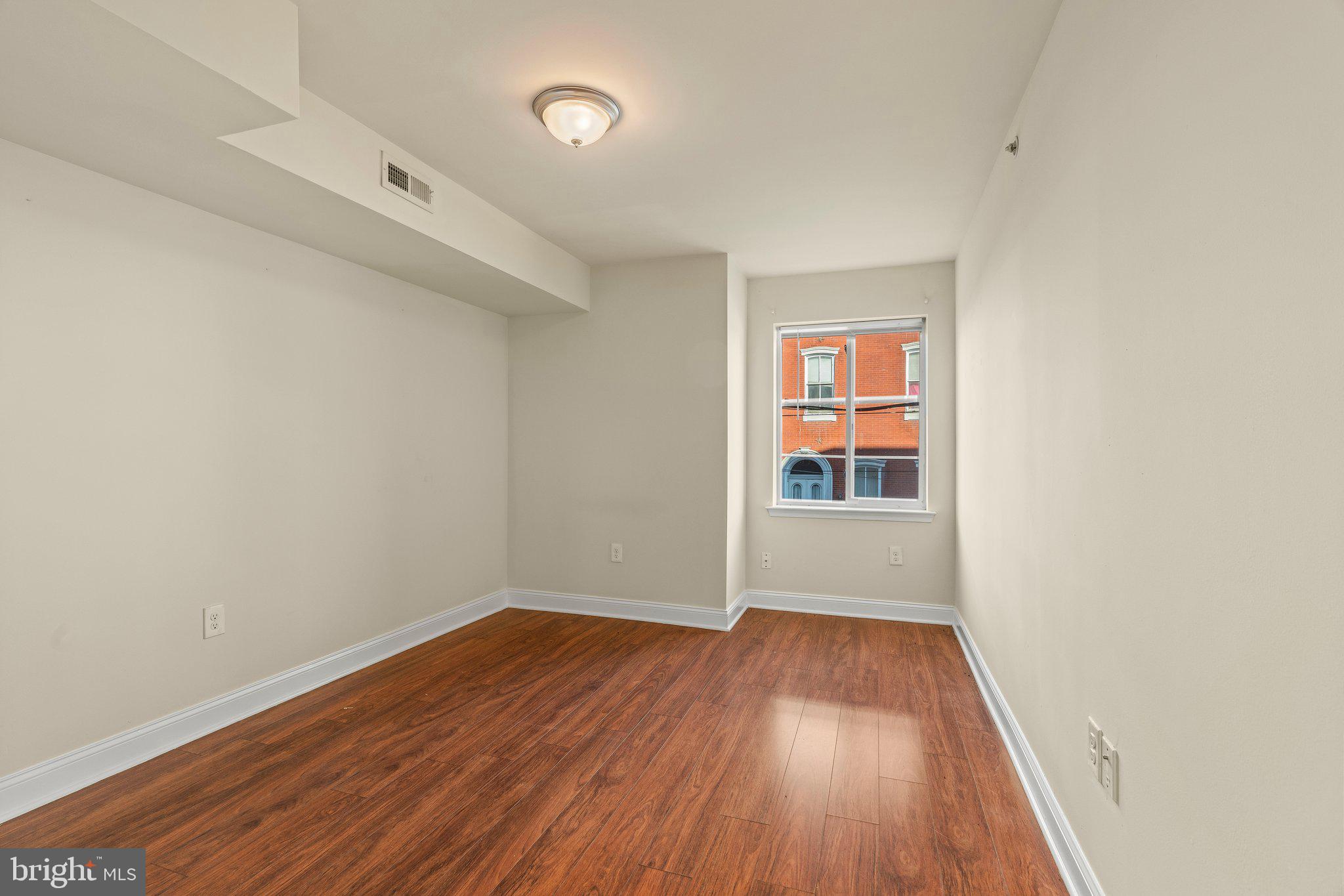 1724 Master Street, Unit C Philadelphia, PA 19121 - Photo 8 of 26 an empty room with wooden floor and windows