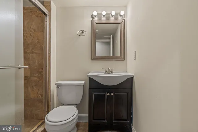 a bathroom with a toilet a sink and mirror