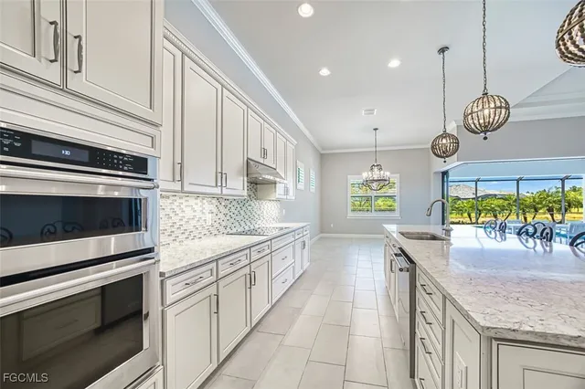 a view of an empty room with window and chandelier
