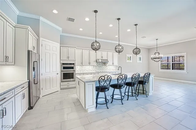 a kitchen with granite countertop a white cabinets and chairs