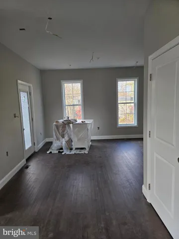 a view of a livingroom with wooden floor and a window