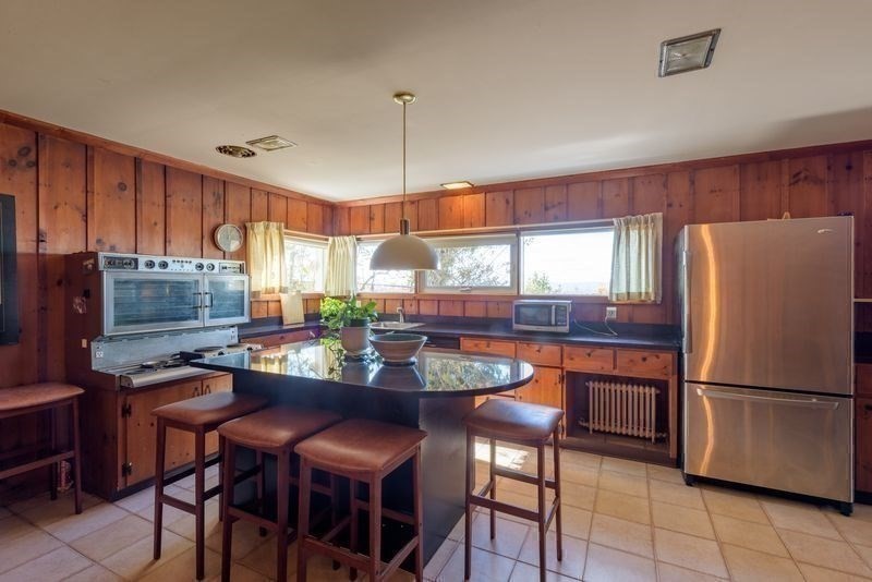 41 Arnold Road Pelham, MA 01002 - Photo 32 of 42 a kitchen with stainless steel appliances granite countertop a stove a refrigerator a sink a dining table and chairs