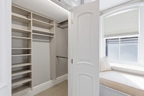 a view of walk in closet with empty racks