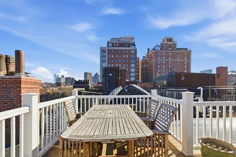 a view of a roof deck with two couches and wooden floor