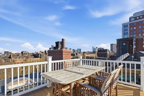 a view of a roof deck with two couches and wooden floor