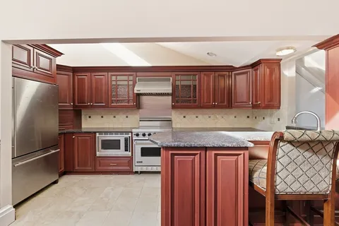 a kitchen with stainless steel appliances granite countertop a refrigerator stove and sink