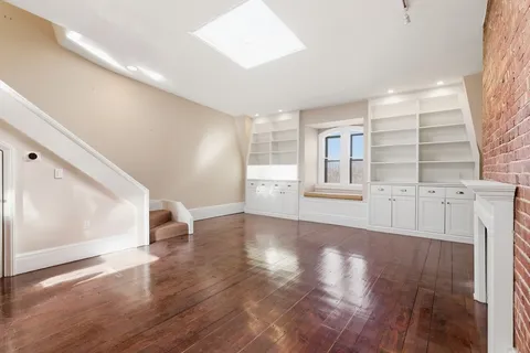 a view of a livingroom with wooden floor and stairs