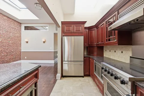 a kitchen with stainless steel appliances granite countertop a refrigerator and a stove