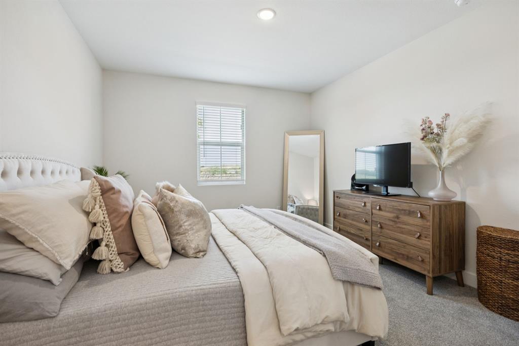 1415 Potenza Road Fate, TX 75087 - Photo 11 of 29 a bedroom with a bed and a television
