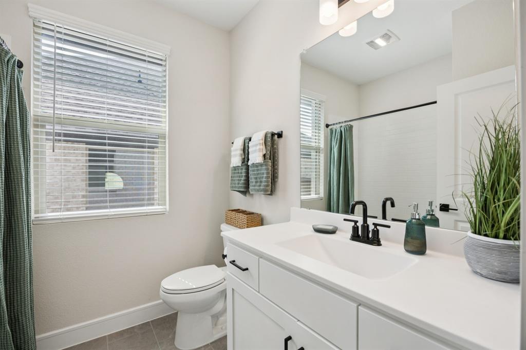 1415 Potenza Road Fate, TX 75087 - Photo 18 of 29 a bathroom with a sink a mirror and a toilet
