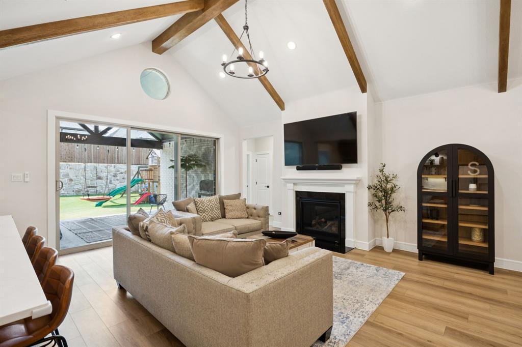 1415 Potenza Road Fate, TX 75087 - Photo 19 of 29 a living room with furniture a fireplace and a flat screen tv