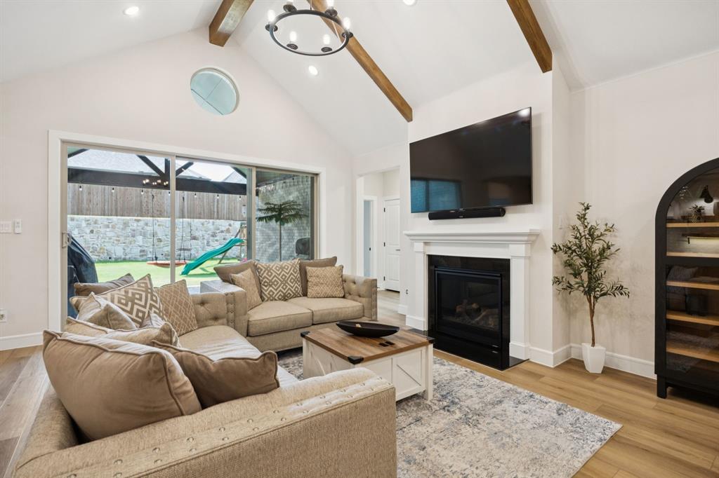 1415 Potenza Road Fate, TX 75087 - Photo 22 of 29 a living room with furniture a fireplace and a flat screen tv