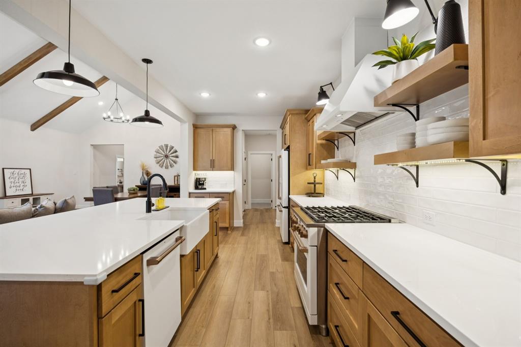 1415 Potenza Road Fate, TX 75087 - Photo 3 of 29 a kitchen with a sink a stove and a refrigerator