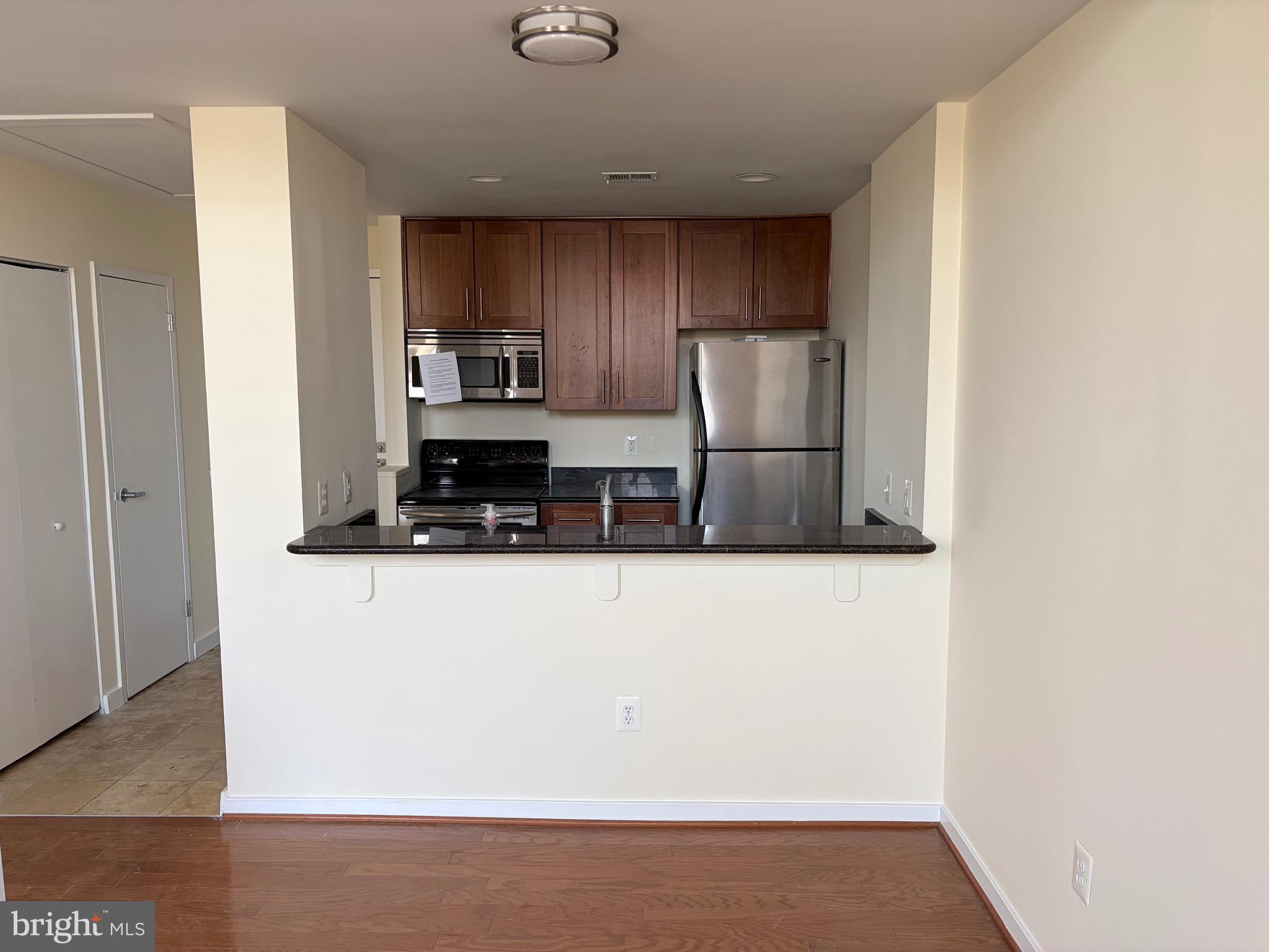 2639 Boston Street, Unit 102 Baltimore, MD 21224 - Photo 3 of 6 a kitchen with stainless steel appliances a refrigerator and a stove top oven