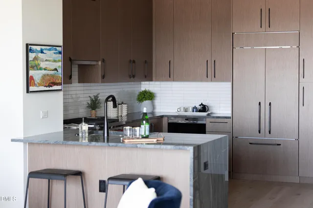 a living room with stainless steel appliances kitchen island furniture and a kitchen view