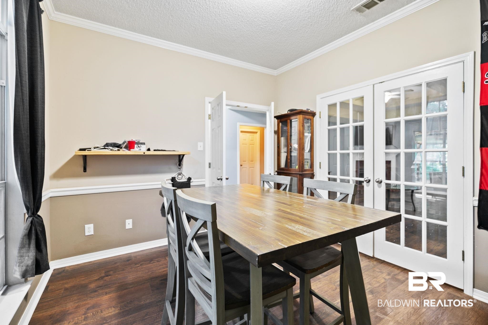10550 Patrick Avenue Grand Bay, AL 36541 - Photo 14 of 43 Dining space with dark hardwood / wood-style floors, crown molding, french doors, and a textured ceiling
