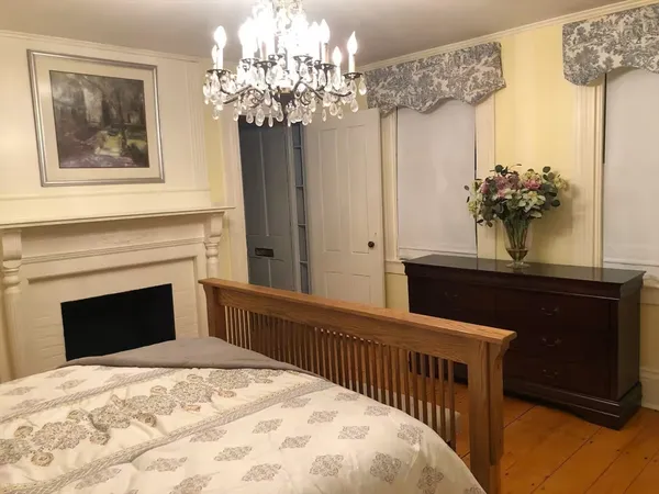 a bedroom with a large bed and a chandelier