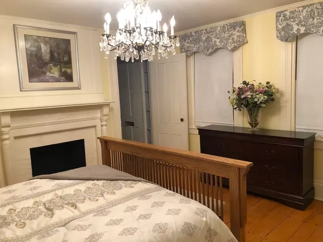 a bedroom with a large bed and a chandelier