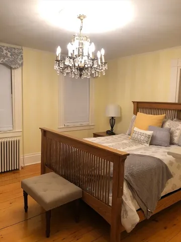 a bedroom with a bed and a chandelier